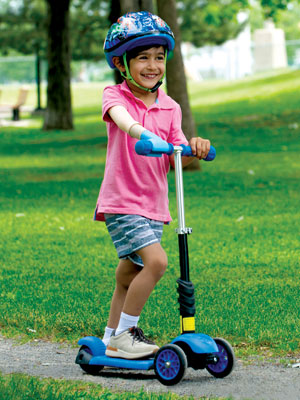 A young male arm amputee uses his scooter on a park's pathway.