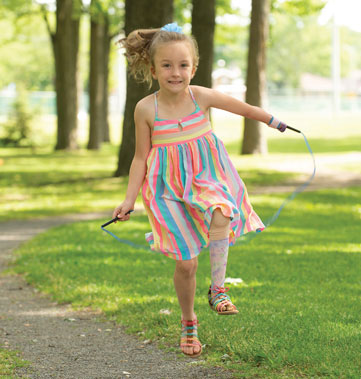 A young left-hand and left-leg amputee jumps rope using her skipping device.